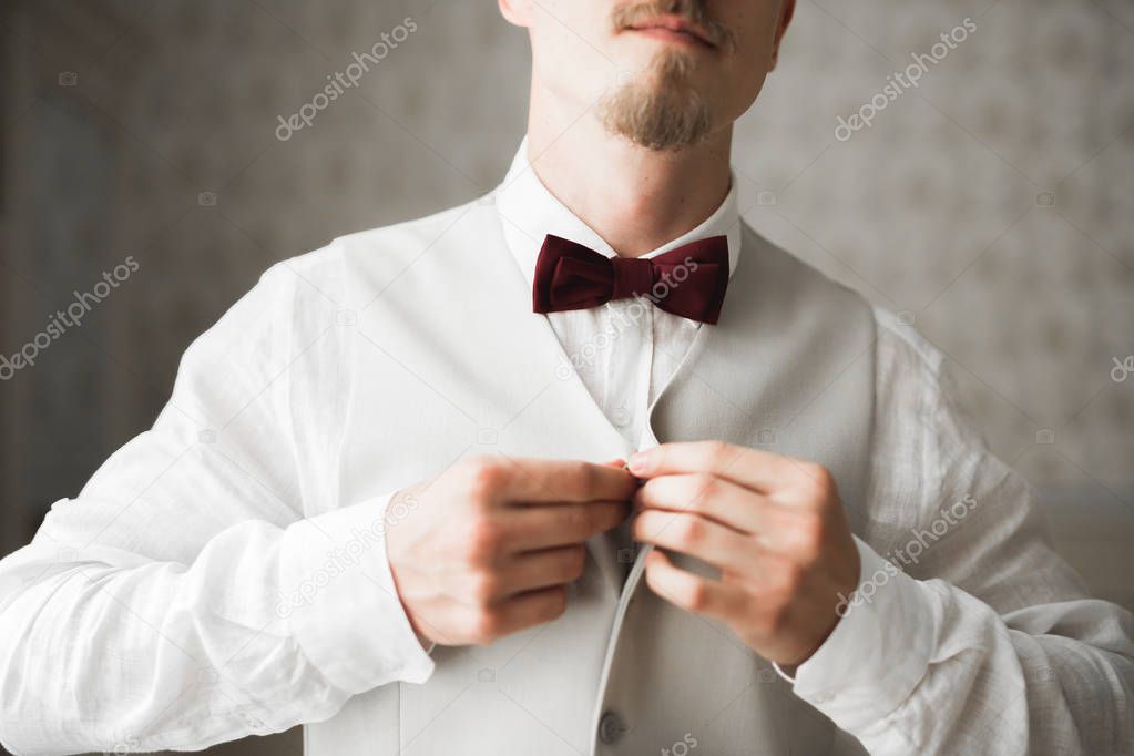 Grooms morning preparation. Handsome man getting dressed and preparing for the wedding.