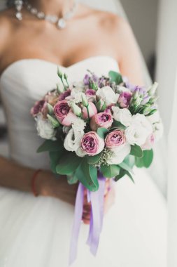 Beyaz elbiseli lüks gelin düğün törenine hazırlanırken poz veriyor.