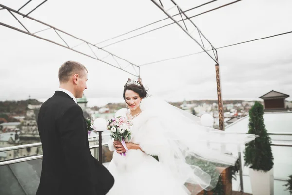 Preciosa pareja feliz boda, novia con vestido blanco largo posando en la hermosa ciudad — Foto de Stock