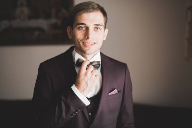 Güzel adam, damat poz veriyor ve düğüne hazırlanıyor.