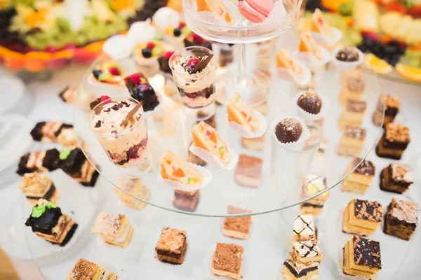 Läckra och välsmakande dessert bord med cupcakes skott i receptionen närbild — Stockfoto