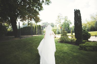 Gelinlik içinde dışarıda poz veren güzel gelin.