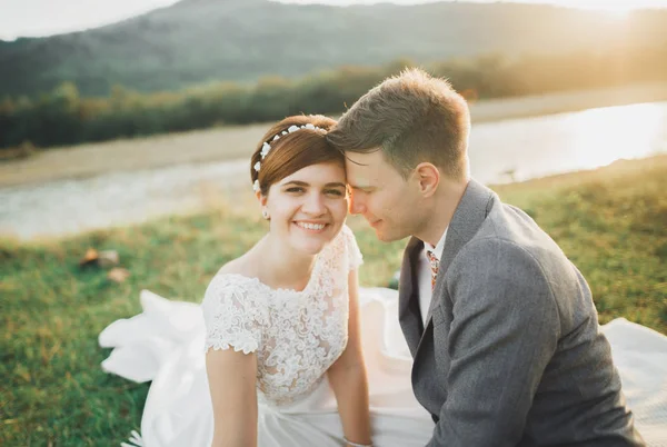 Mooie bruidspaar, bruid en bruidegom, verliefd op de achtergrond van bergen — Stockfoto