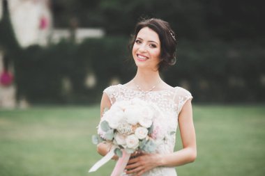 Gelinlik içinde dışarıda poz veren güzel gelin.