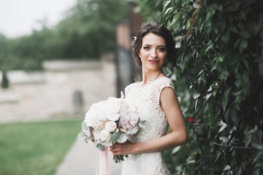 Parkta poz veren gelinlikli güzel, lüks bir gelin.