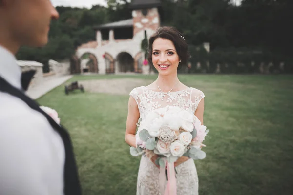 Bella coppia di nozze felice, sposa con abito lungo bianco in posa nella bella città — Foto Stock