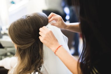 Cüppeli muhteşem gelin bir odada düğün töreni için poz veriyor ve hazırlanıyor.