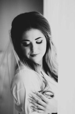 Beyaz elbiseli lüks gelin düğün törenine hazırlanırken poz veriyor.