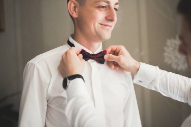 Güzel adam, damat poz veriyor ve düğüne hazırlanıyor.