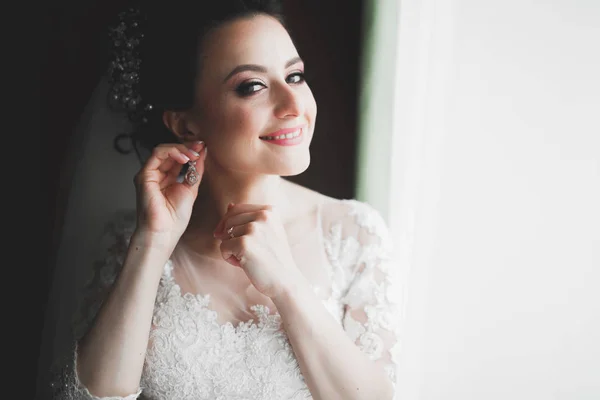 Luxus menyasszony fehér ruhában pózol, miközben készül az esküvői szertartás — Stock Fotó