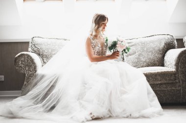 Beyaz elbiseli lüks gelin düğün törenine hazırlanırken poz veriyor.