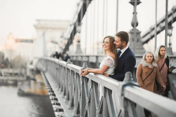 Joven hermosa pareja elegante de recién casados en un puente — Foto de Stock