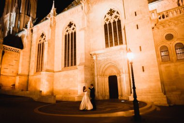 Harika bir tarihi binanın yakınında mükemmel bir elbiseyle dönen güzel bir gelin.