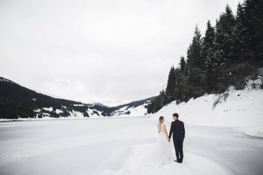Göz kamaştırıcı mutlu çift birbirine yakın duruyor ve gözlerinin içine bakıyor.
