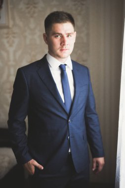 Güzel adam, damat poz veriyor ve düğüne hazırlanıyor.