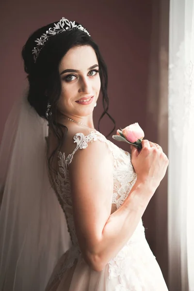 Linda noiva em roupão posando e se preparando para o rosto cerimônia de casamento em uma sala — Fotografia de Stock