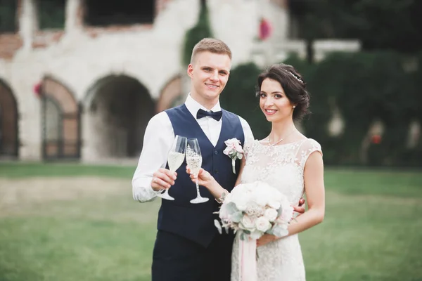 Lovely happy wedding couple, bride with long white dress posing in beautiful city — Stock Photo, Image