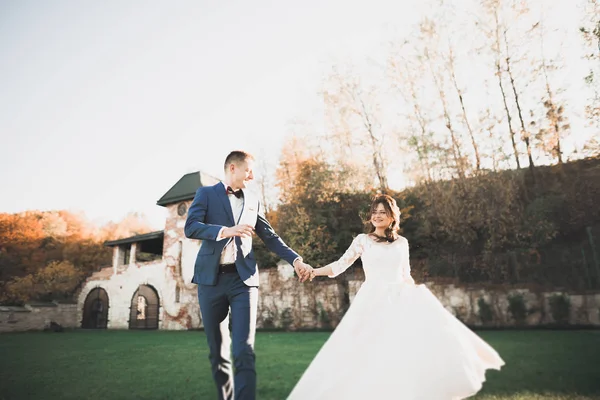 Casal feliz encantador do casamento, noiva com vestido branco longo posando na cidade bonita — Fotografia de Stock