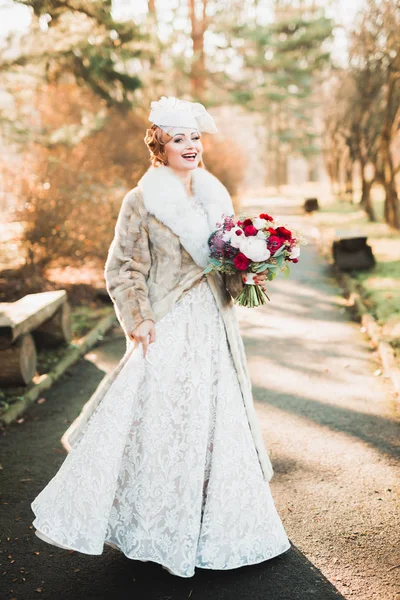 Hermosa novia joven de lujo en vestido de novia posando en el parque — Foto de Stock