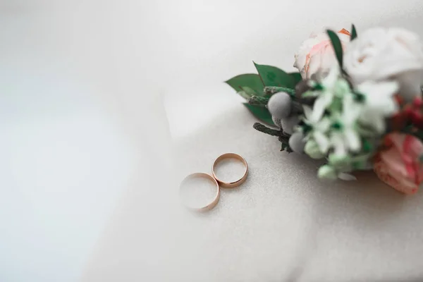 Imagem tonificada bonita com anéis de casamento contra o fundo de um buquê de flores — Fotografia de Stock