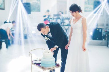 Gelin ve damat düğün pastasını kesiyor.