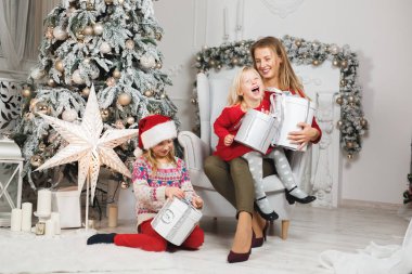Anne ve çocukları Noel ağacının yanında kutluyorlar.