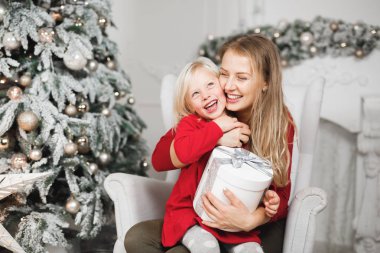 Anne ve kızları küçük kızların doğum günü hediyelerini açıyorlar.