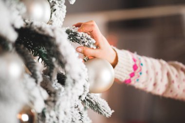 Güzel bir Noel ağacını süsleyen mutlu kız.