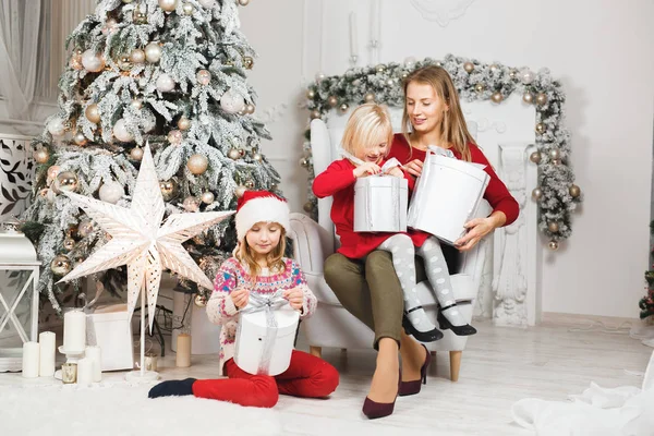 Mère et ses filles ouvrant le cadeau d'anniversaire des petites filles — Photo