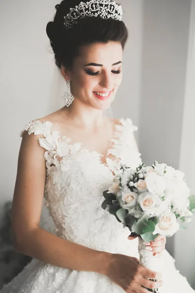 Linda noiva em roupão posando e se preparando para o rosto cerimônia de casamento em uma sala — Fotografia de Stock