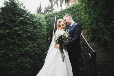 Çiçek buketi taşıyan mükemmel bir düğün çifti.