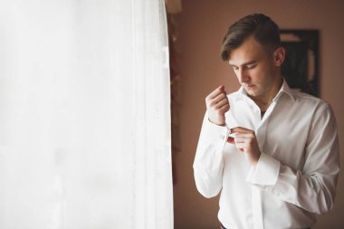 Güzel adam, damat poz veriyor ve düğüne hazırlanıyor.