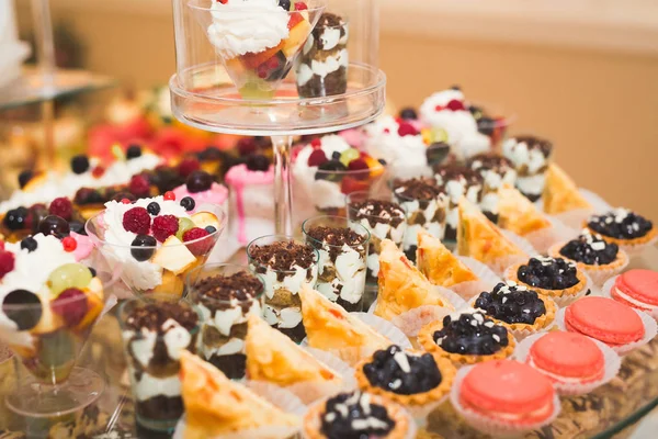 Deliziosi dolci sul buffet di caramelle nuziali con dessert, cupcake — Foto Stock