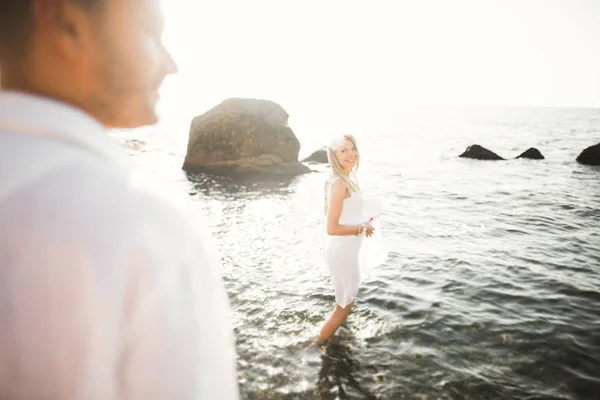 Casamento casal apenas andando na praia ao pôr do sol . — Fotografia de Stock