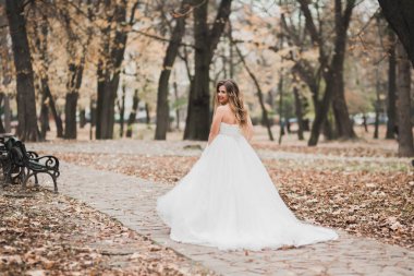 Gelinlik içinde dışarıda poz veren güzel gelin.