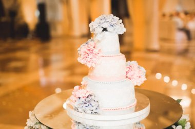 Masada süslü düğün pastası var.