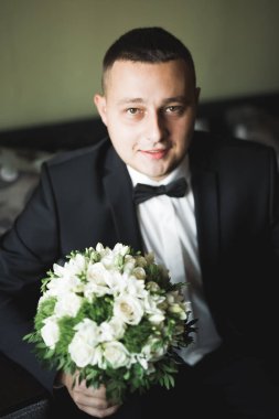 Güzel adam, damat poz veriyor ve düğüne hazırlanıyor.