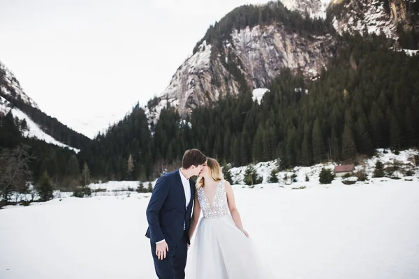 Jeune couple heureux baisers, montagnes paysage dans la neige sur le fond — Photo