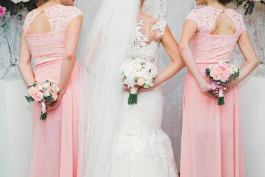 Gelin çiçekli büyük ve güzel bir düğün buketi tutuyor.