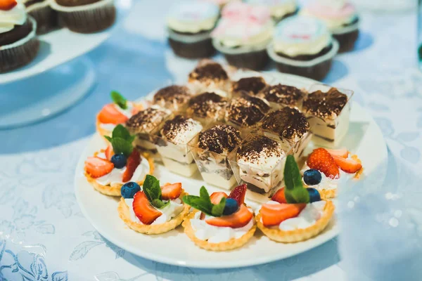 Deliciosos dulces en el buffet de dulces de boda con postres, cupcakes — Foto de Stock