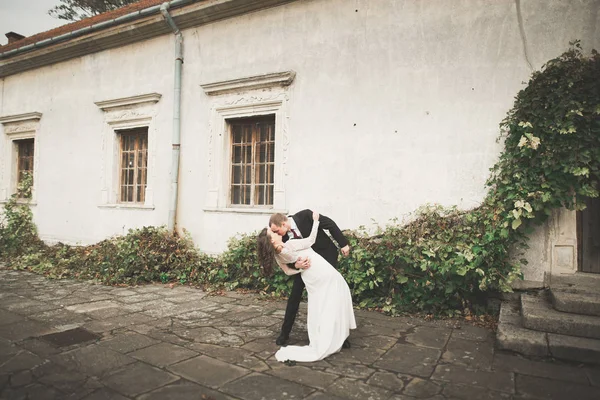 Mooi sprookje pasgetrouwd koppel knuffelen in de buurt van oud middeleeuws kasteel — Stockfoto