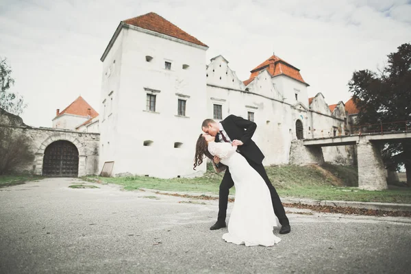 Mooi sprookje pasgetrouwd koppel knuffelen in de buurt van oud middeleeuws kasteel — Stockfoto