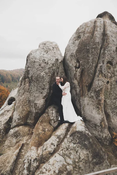 Γάμος ζευγάρι στην αγάπη φιλιά και αγκάλιασμα κοντά σε βράχους στο όμορφο τοπίο — Φωτογραφία Αρχείου