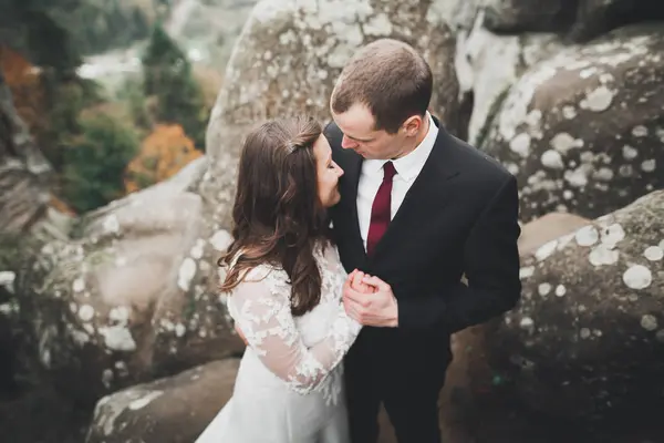 Casamento casal no amor beijando e abraçando perto de pedras na bela paisagem — Fotografia de Stock