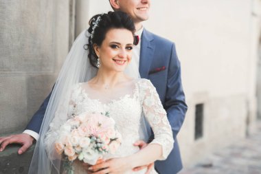 Güzel, mutlu bir düğün çifti, güzel şehirde uzun beyaz elbiseli bir gelin.