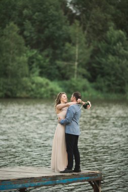 Sevimli gelin, dağlar ve günbatımı manzara Gölü üzerinde zarif damat. Muhteşem Düğün çifti