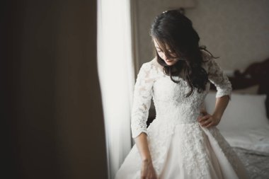 Tüylü, lüks makyaj, saç stili, stüdyo içi fotoğraf çekimi olan güzel bir gelin.