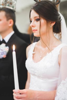 Gelin ve damat kilisede mum tutuyorlar.