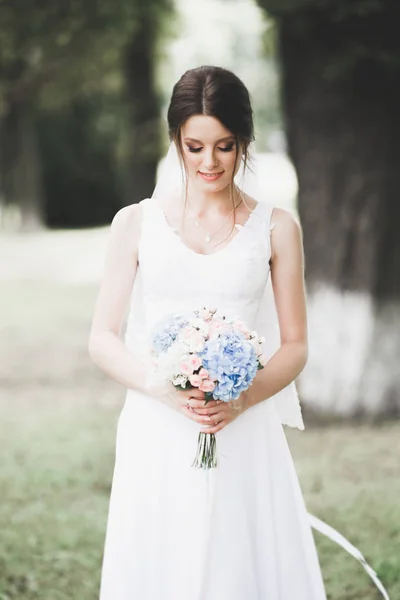 Hermosa novia posando en vestido de novia al aire libre — Foto de Stock