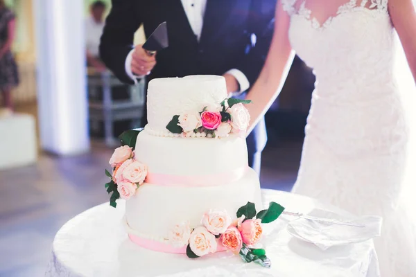 Novia y novio en la boda de corte de la torta de boda — Foto de Stock